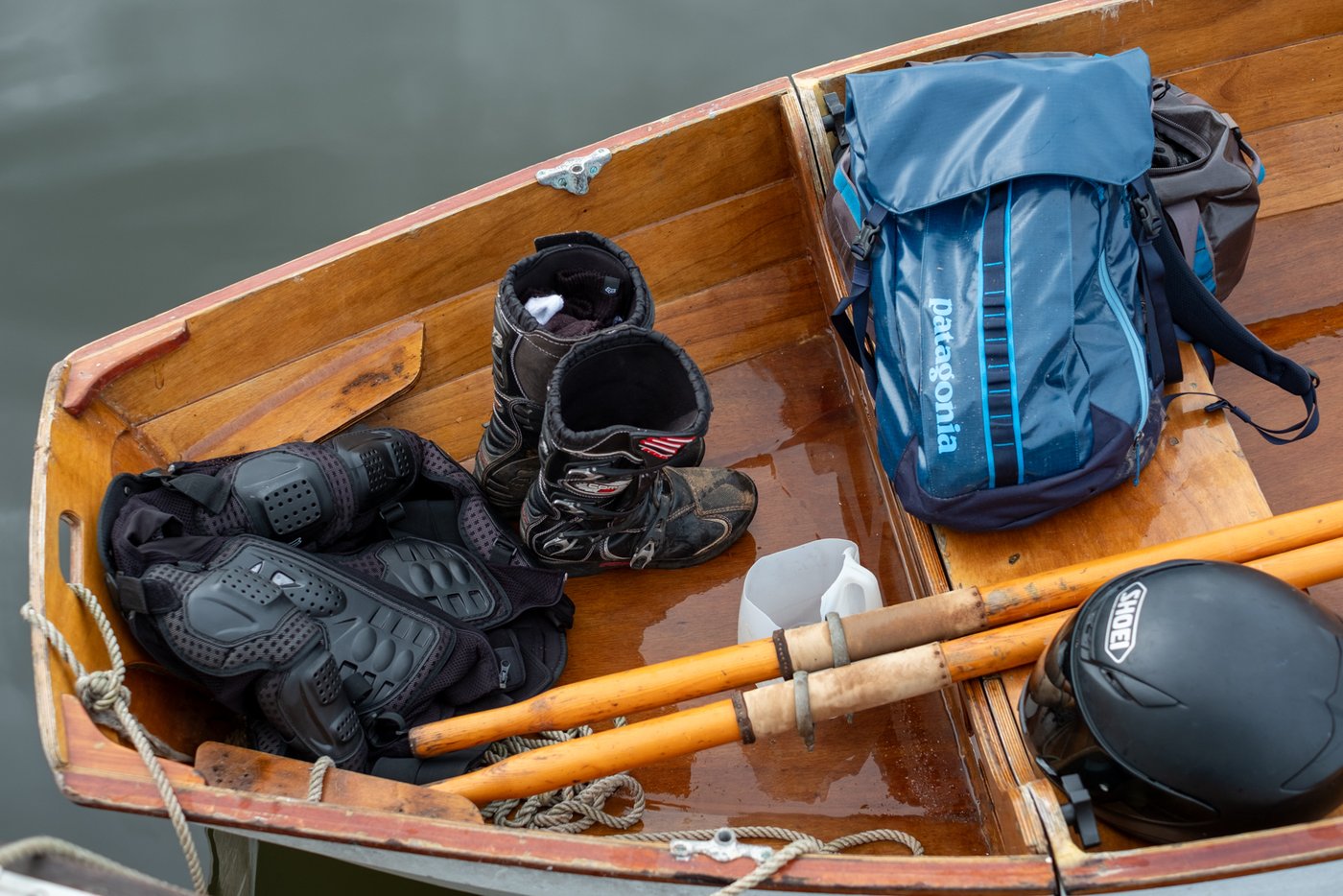 Motorcycle gear and Patagonia pack in a wooden rowboat