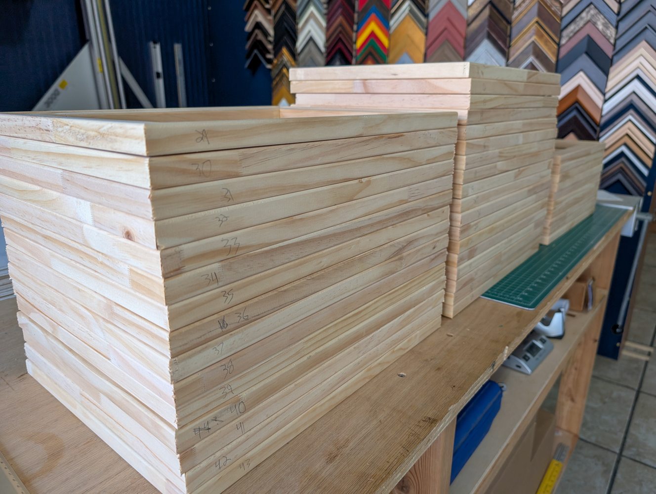 Hand-built canvas stretcher bars stacked in the shop